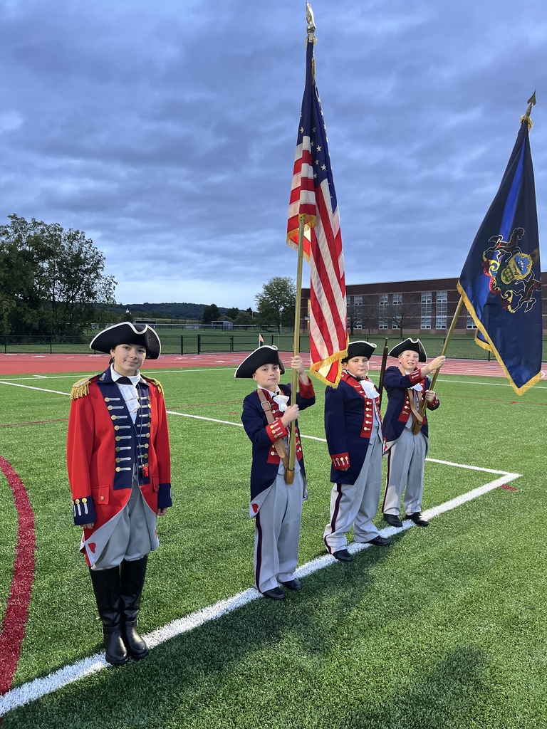 Marching Band drum major and honor guard standing and posing on the field