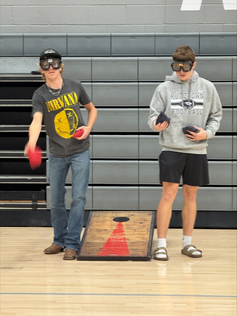 Students are using driving simulator goggles playing corn hole