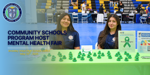 Two students smile towards camera at mental health fair. Text states: Community Schools Program Hosts Mental Health Fair