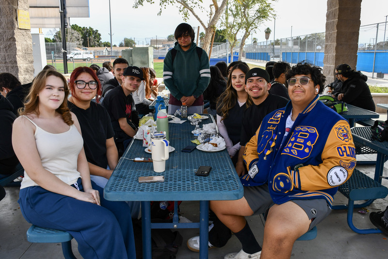 Senior students sit at lunch table enjoying breakfast.