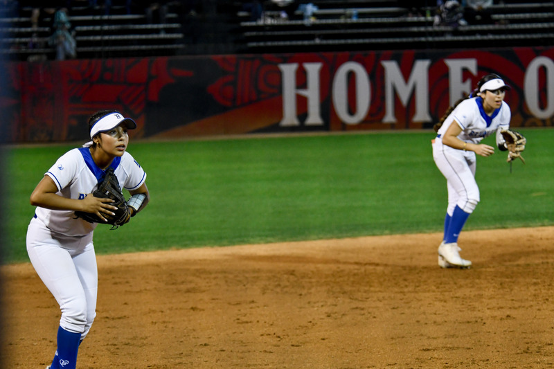 Outfields players stand ready looking at batter.