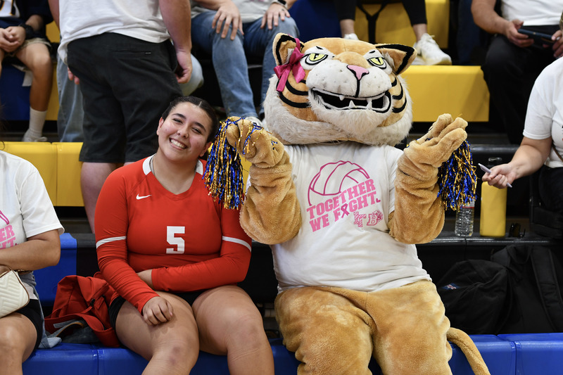 Imperial junior varsity player poses next to Wilma the wildcat.