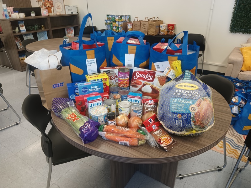 Donated items are placed on the table,. turkey, canned food, carrots and celery
