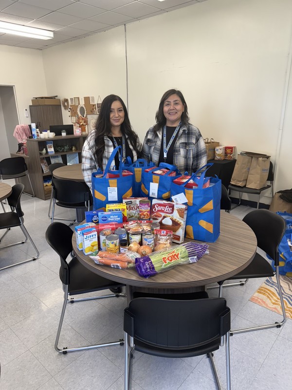 Community School staff poses next to donated items.