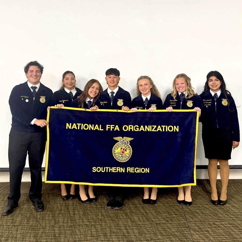 Student Aubrey Cazares, holds Southern Region FFA Banner alongside 6 other offices.