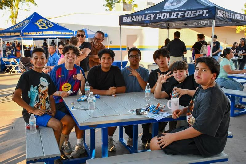 Students pose for picture smiling and holding snacks