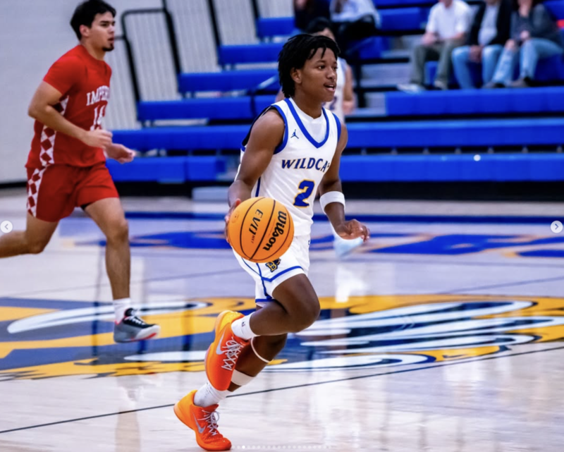 Jayden Travis dribbles the ball across the court during basketball game