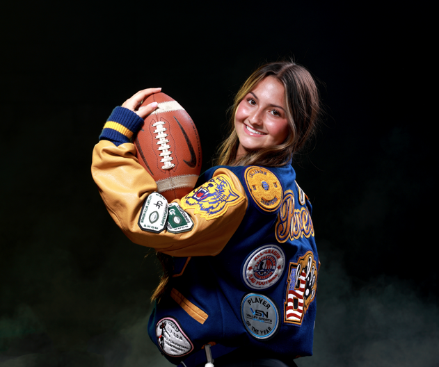 Jacey Reeves holds up football and poses for photo.