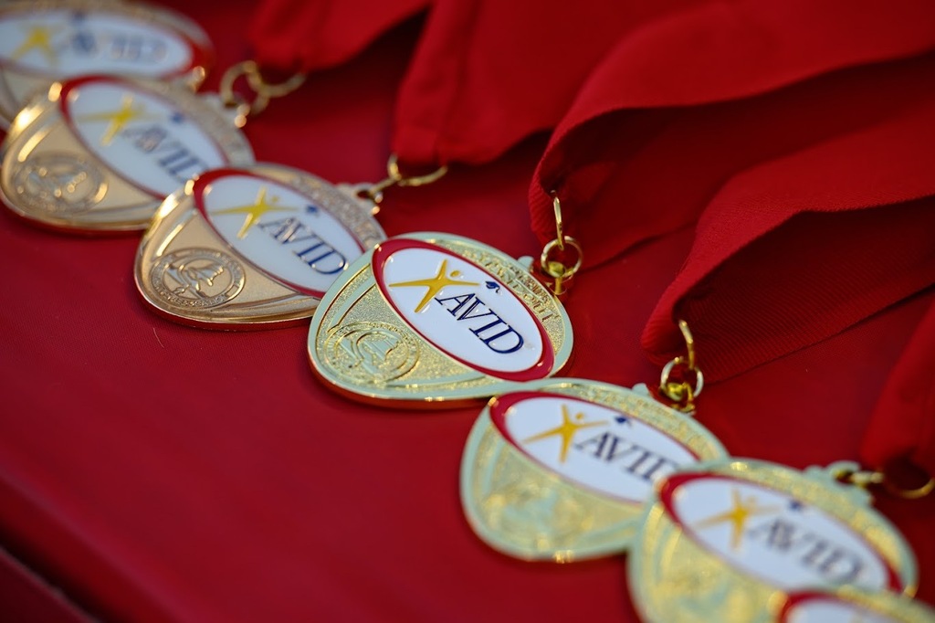 Gold AVID medals with red ribbon lay on a red tablecloth