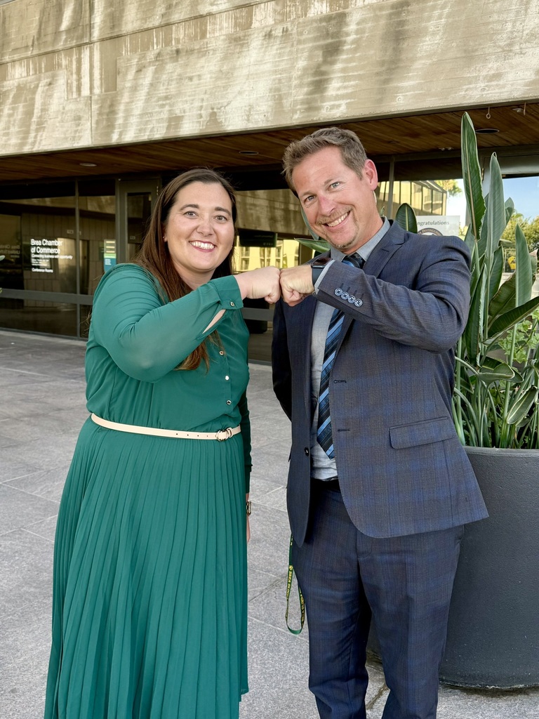a photo of nicole bear and brandon frank holding up their fist bumps to one another