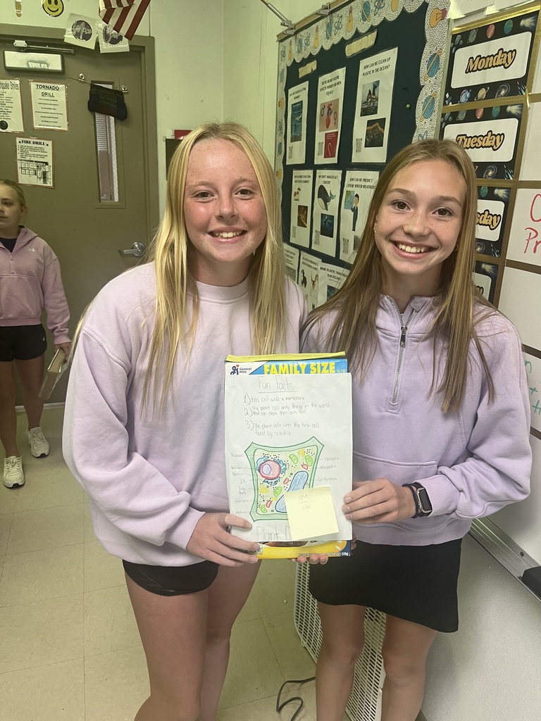 7th graders posing with their finished cereal box cell projects 