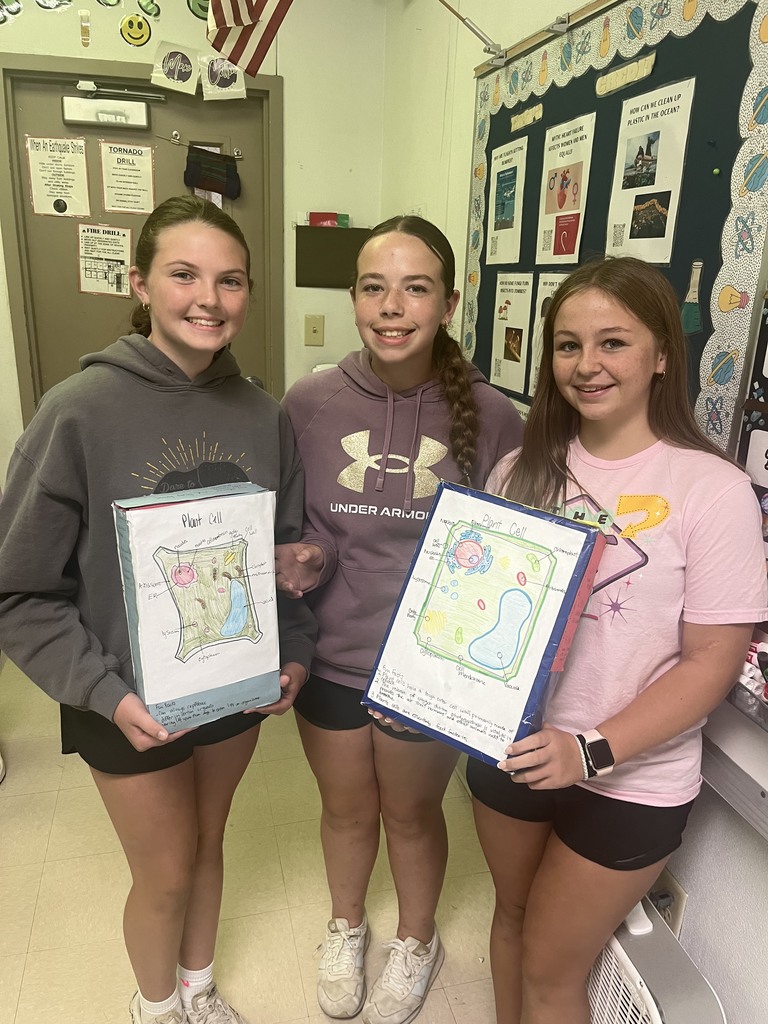 7th graders posing with their finished cereal box cell projects 