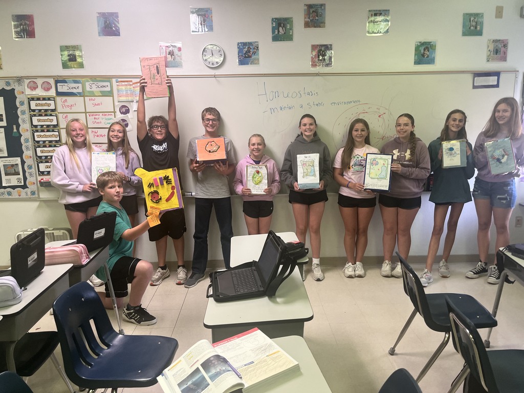 7th graders posing with their finished cereal box cell projects 