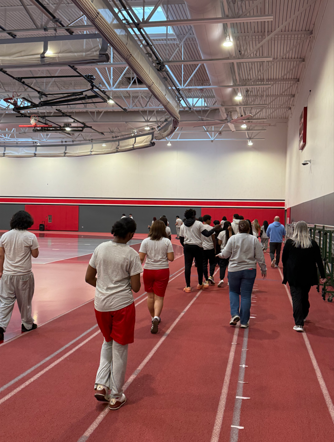 Students and staff walk together on the indoor track inside Bremen High School’s fieldhouse during Mindful Moments Week as part of a schoolwide wellness walking challenge.