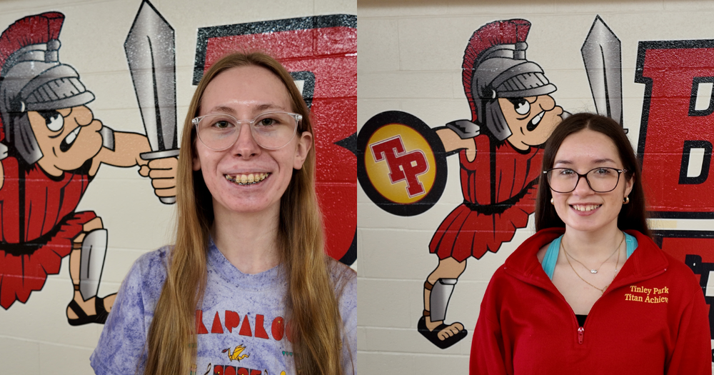Nadia Mazon (right) and Peyton Leonhardt (left) stand in front of Tinley Park High School mural posing for a photo. A red titan can be seen behind them with a shield that reads "TP" in red letters.