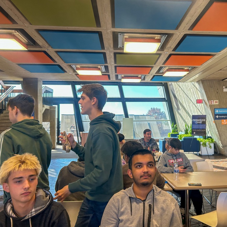 A group of highschool students sitting and eating