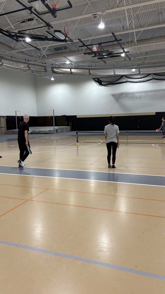 A man and a woman playing pickleball