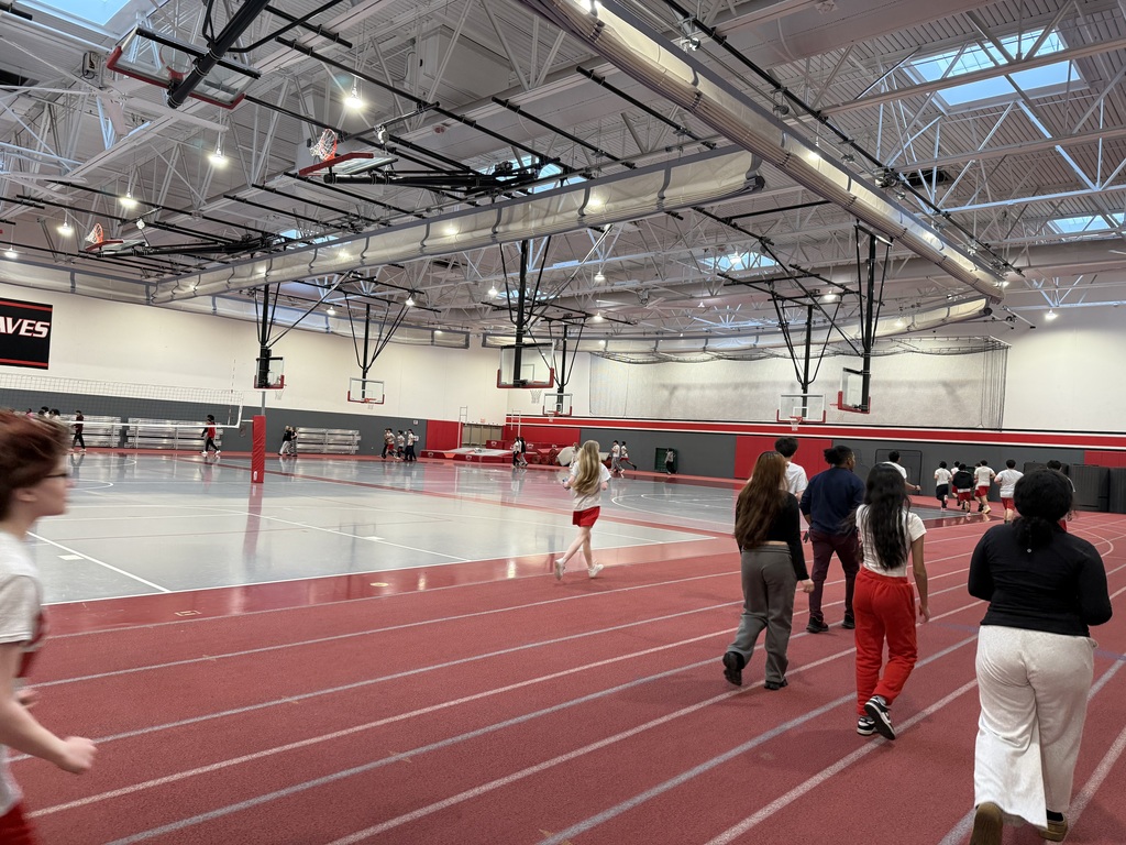 Students and staff walk together on the indoor track inside Bremen High School’s fieldhouse during Mindful Moments Week as part of a schoolwide wellness walking challenge.