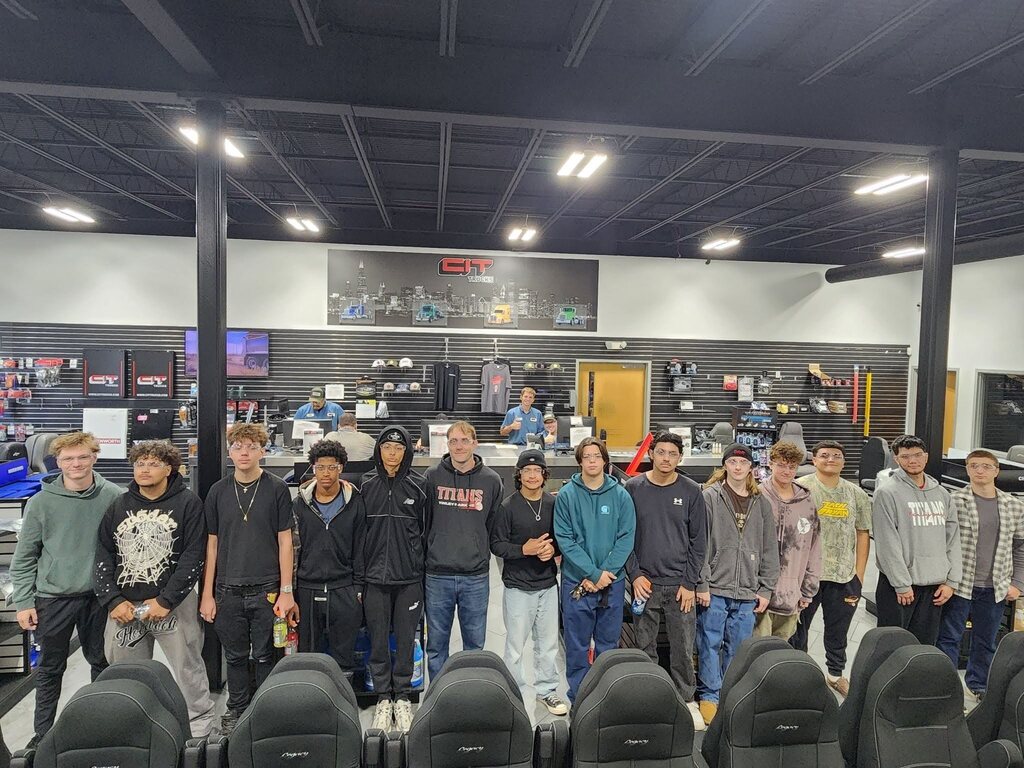 Students pose for a group photo inside the CIT Trucks facility during a Manufacturing Week tour.