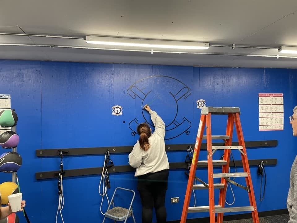 Art Club painting a mural at the OF baseball association field house in Convent Park.