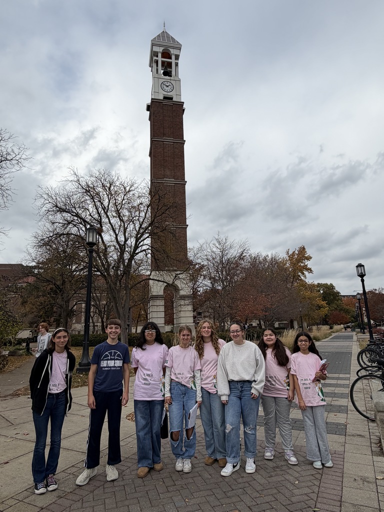 Students standing in front of a tower. 