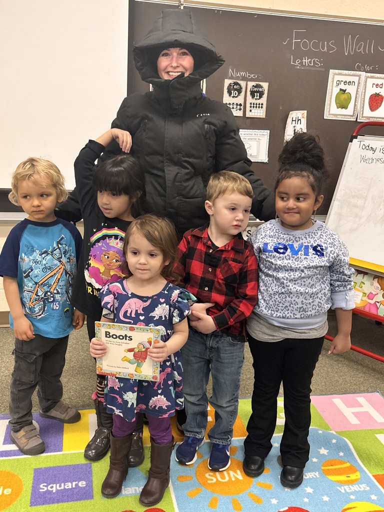 Students standing in front of a teacher.