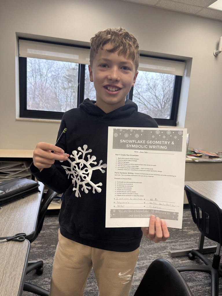 Student in black sweatshirt holding a snowflake.