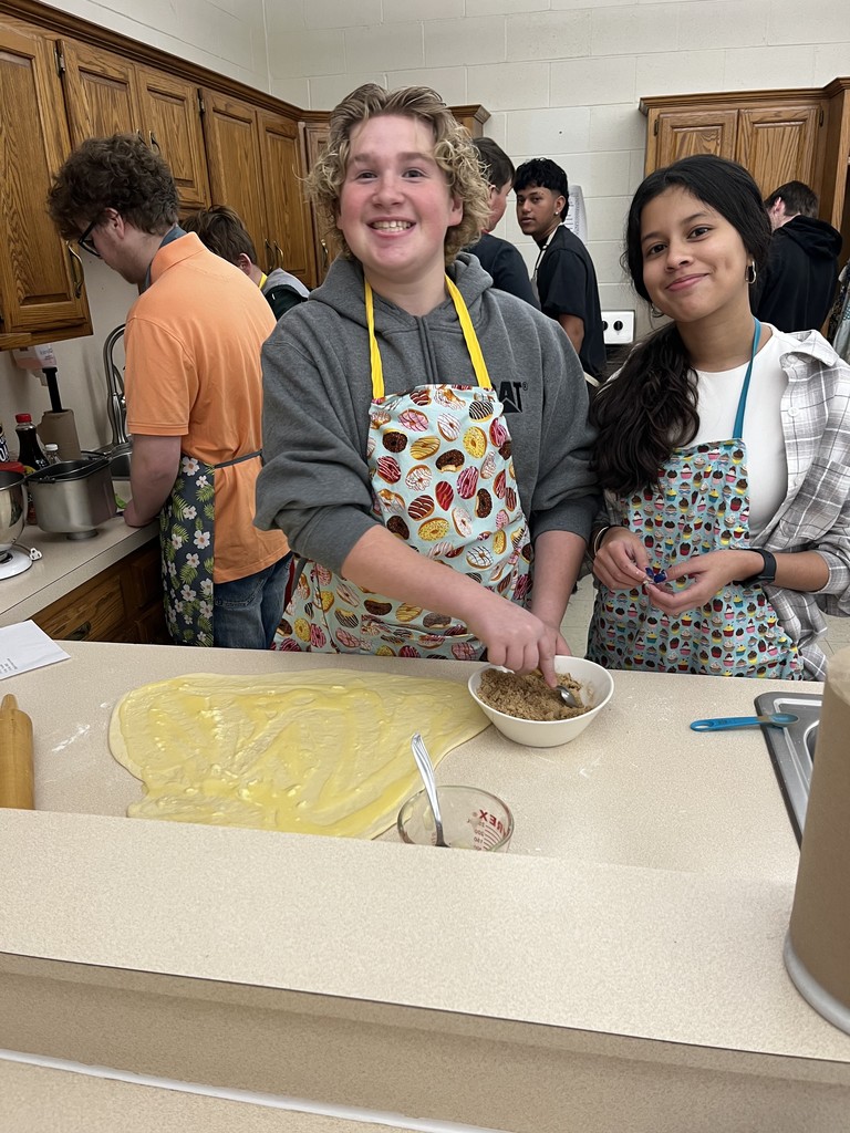 BHS Students putting filling into a rolled out dough.