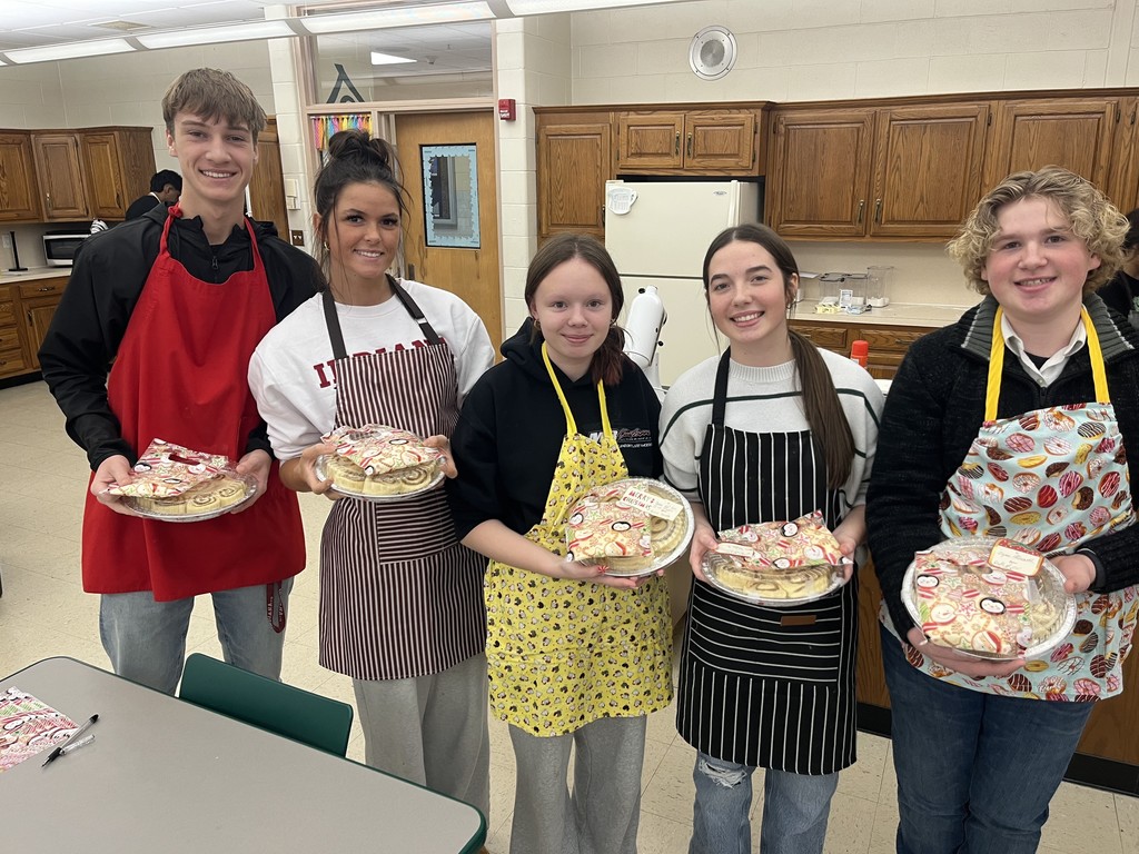 Five BHS Students Holding a plate of uncooked  cinnamon rolls to take home and bake.
