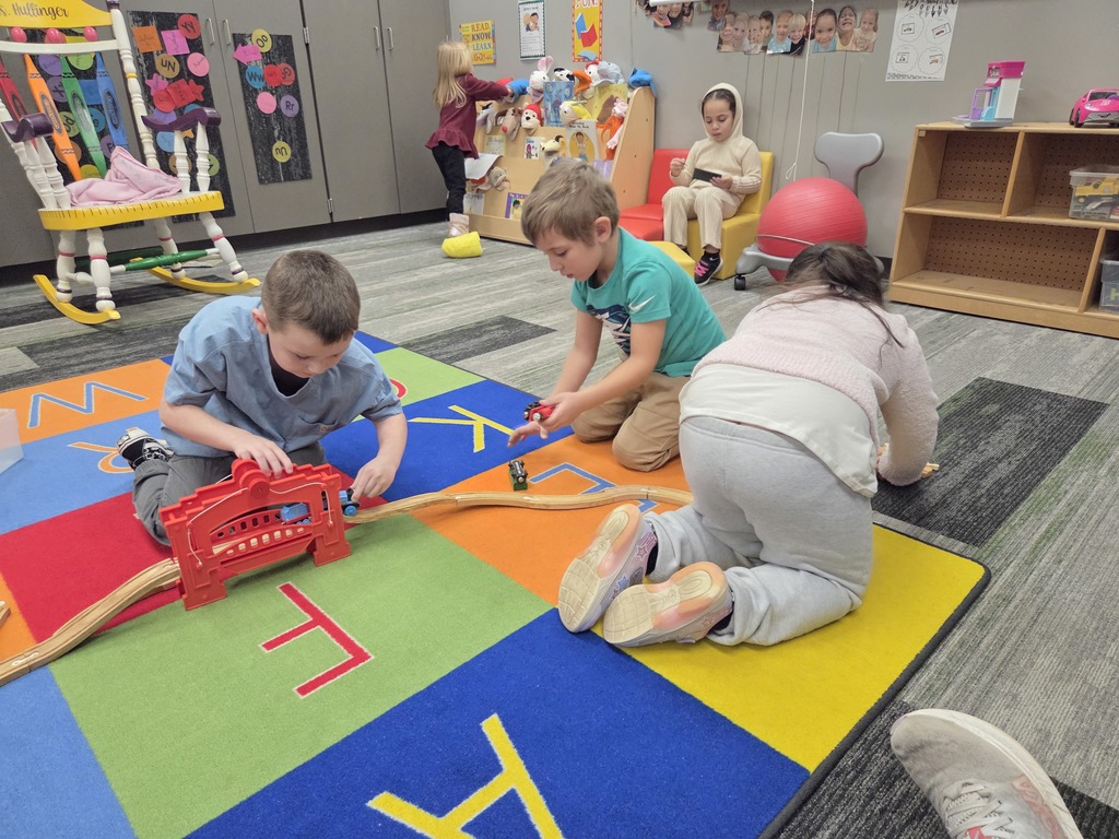 students working hard on a play train track