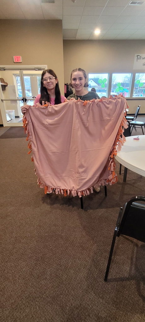 2 girls holding a pink blanket