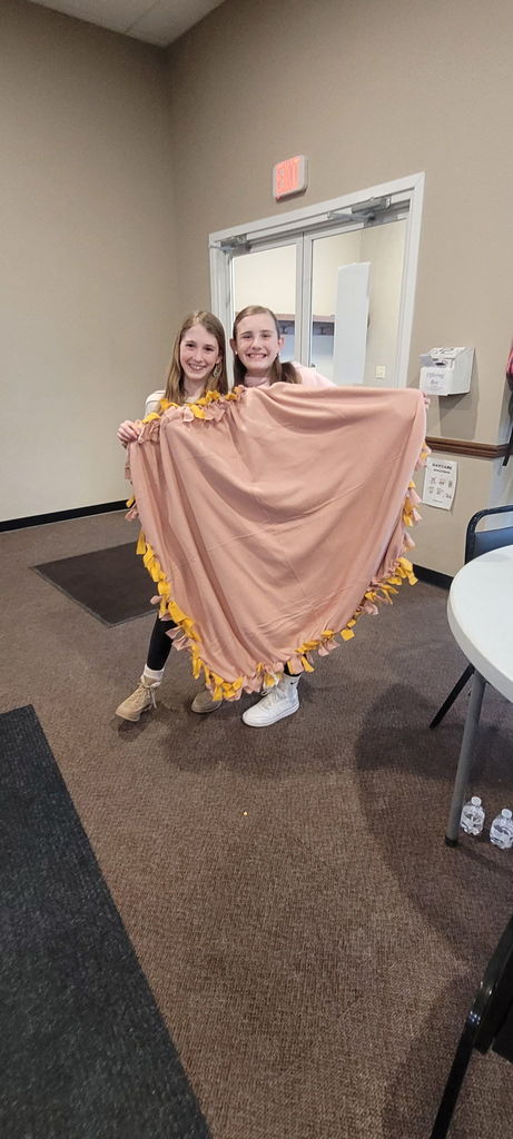 2  girls holding a pink blanket