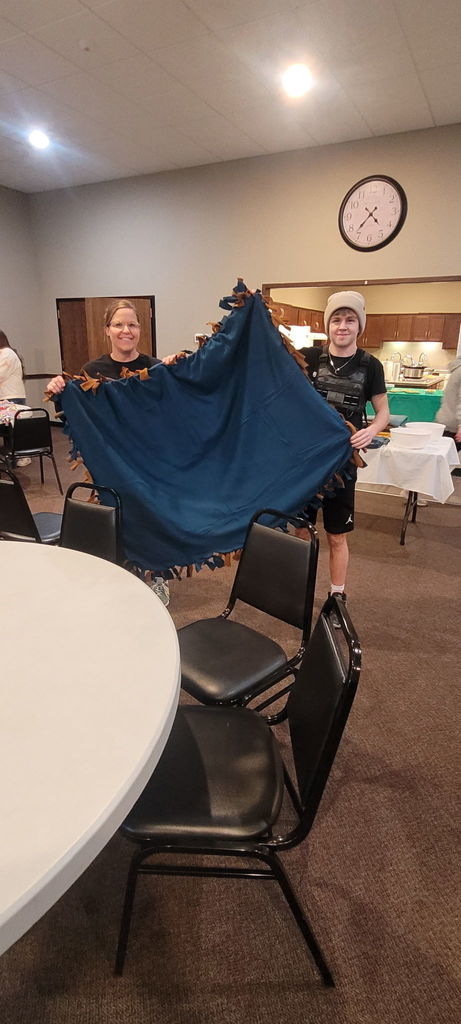2 people holding a blue blanket