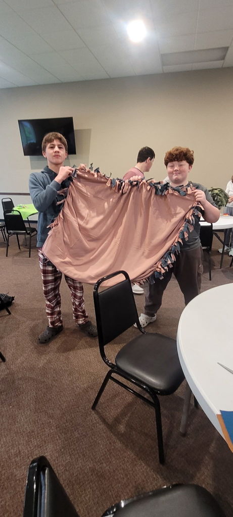 2 boys holding a brown blanket