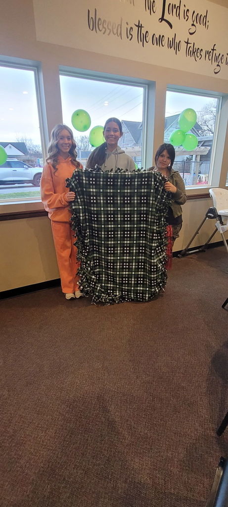 3 girls holding up a blanket