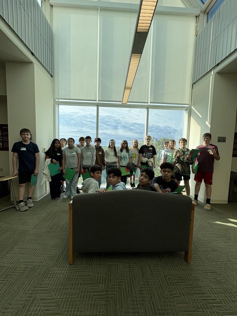 A group of students standing in a door room.