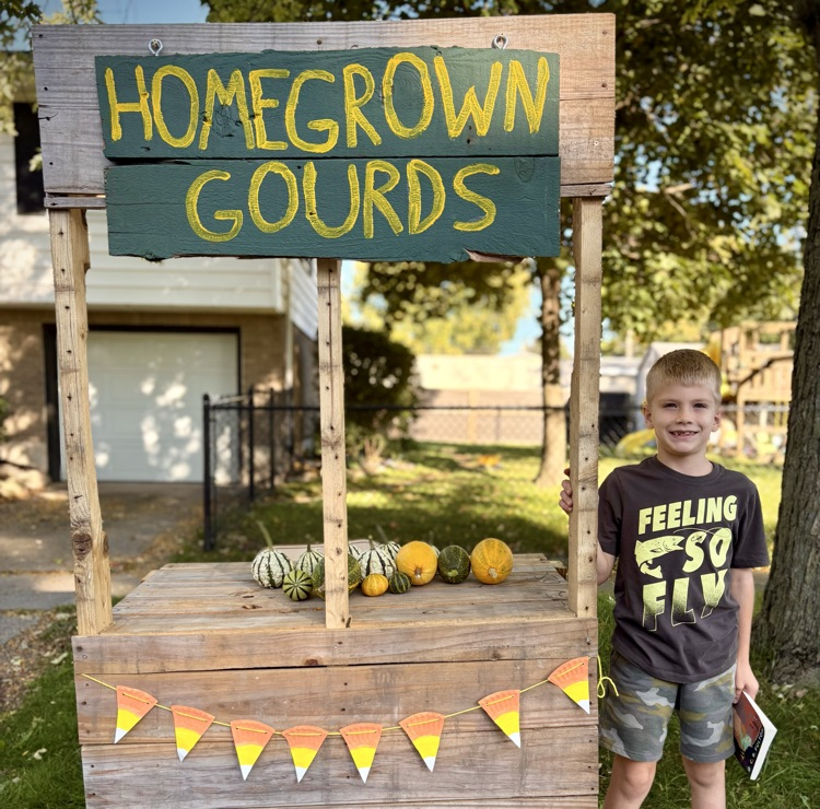 homegrown gourds stand with kid