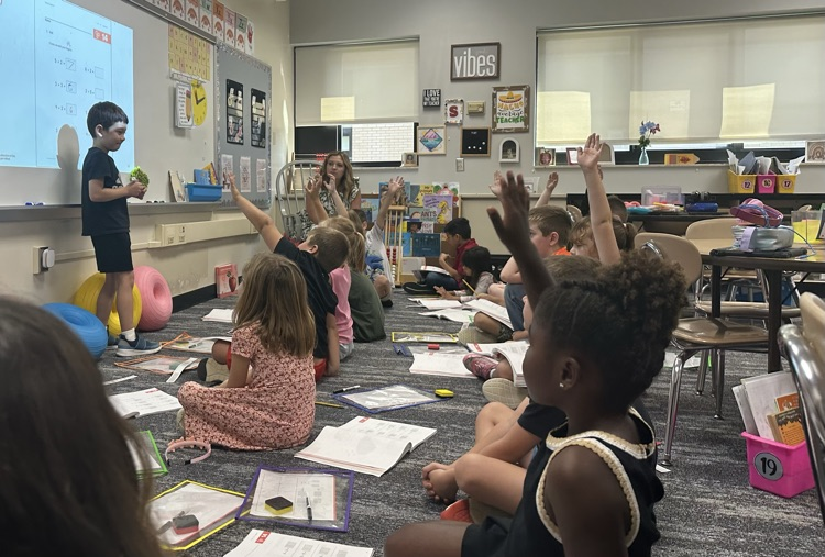 kids raising hands in class 