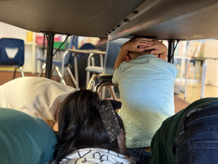 Kindergartner protecting  their head 