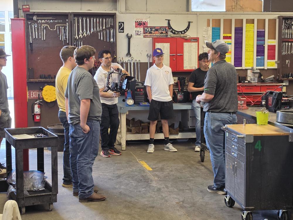 The Education Talk Show camera crew interviewing Mr. Sooter in Auto Shop