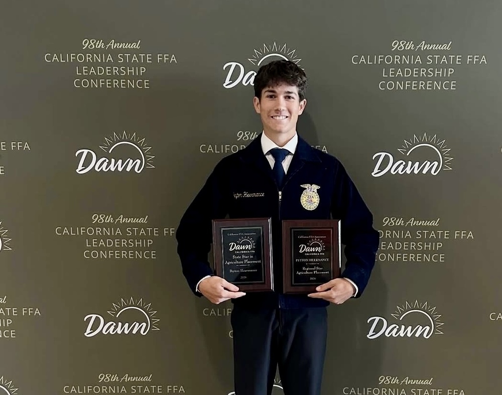 Peyton Heermance, a two-time state champion, holding plaques at state convention