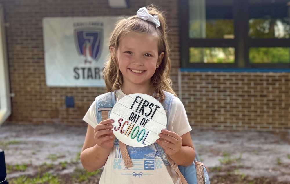 A child arriving for the first day of school at Challenger 7 Elementary