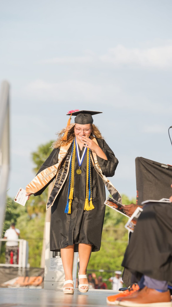 graduating student crossing platform