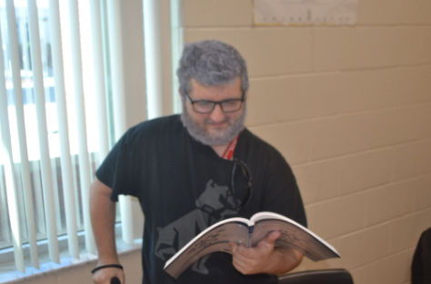 Elderly Eager for Education: Senior Dominic Ciano popping open a financial algebra book within his first period dressed in his senior age. Ciano decided to go with dyed hair, that was done by his Aunt, and carried around a cane found at a good price by his Mother. “We had outfit ideas—But not really—I wanted to wear slippers, that was one thing, but I forgot to put them on.” Ciano said. Photo by Tyler Ferreira Alves Hill.