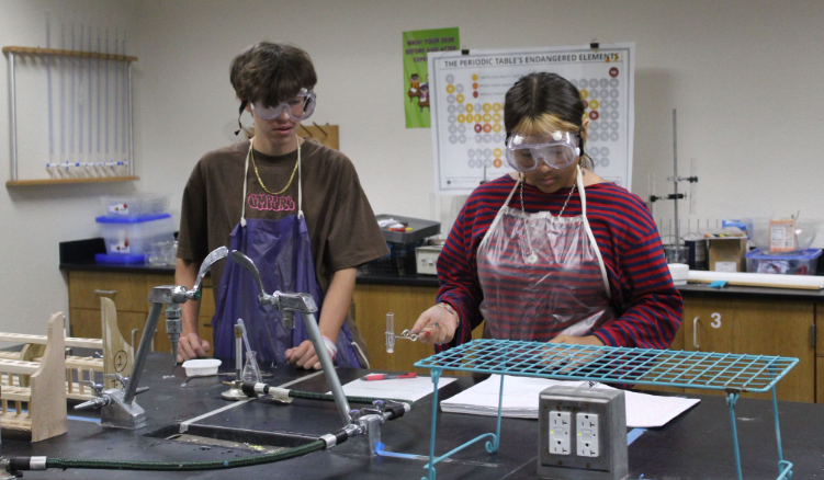 STRANGE CHANGES. During a lab in Ms.Farrahi class, Marisol Comejo (10) and Cash Grey (10) experiment with chemical and physical change. Many tenth graders take chemistry class because it’s an honors course, but they later find out how fun it can actually be. When Comejo was asked why she joined she said, “I got put in it, and it’s in the honor program, but it’s a lot of fun and I would totally recommend to other students.” Comejo says. The chemistry lab gave students hands-on experience while reinforcing lessons from class. Photo by Melissa Amaro.