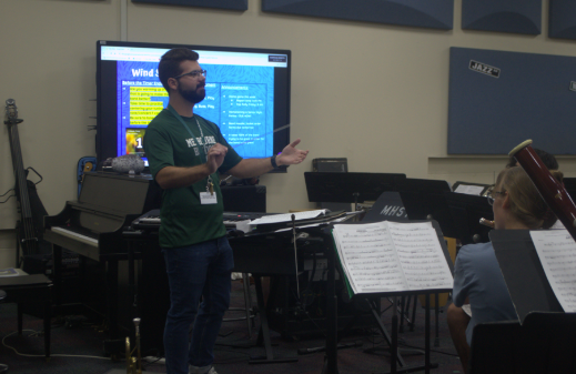 Shaping minds and Sharing the Love of Music. In the band room at Melbourne High School, Andrew Cannella guides students through rehearsals, fostering teamwork and love for music. Band director Andrew Cannella works with students during class in the band room. He leads all grades ranges from freshman, sophomore, junior, and seniors, along with the other band director at Melbourne High School and focuses on building teamwork and musicianship. Canella enjoys seeing students improve each day.Canella said “I love when kids show they appreciate the process and keep working hard.” he said. Photo By: Paige Allen