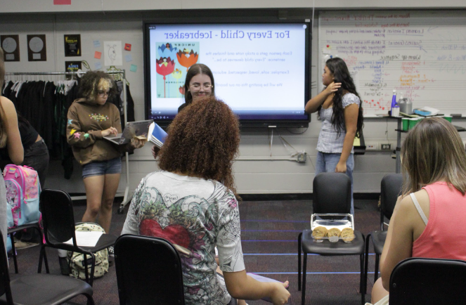 UNITED FOR KIDS: At the first meeting of UNICEF before school on September 12th, members are in Mrs.Taylor’s chorus room participating in an icebreaker and discussing ideas. They talked about new project ideas for this year to raise money. The officers are also giving cookies to all the members. Junior and treasurer Lani Anderson is seen on her computer working on the attendance sheet. She joined UNICEF for reasons similar to many others wanting to make a difference. “I wanted to start giving back more to people who need it” said Anderson. Photo by Ayaana Gupta