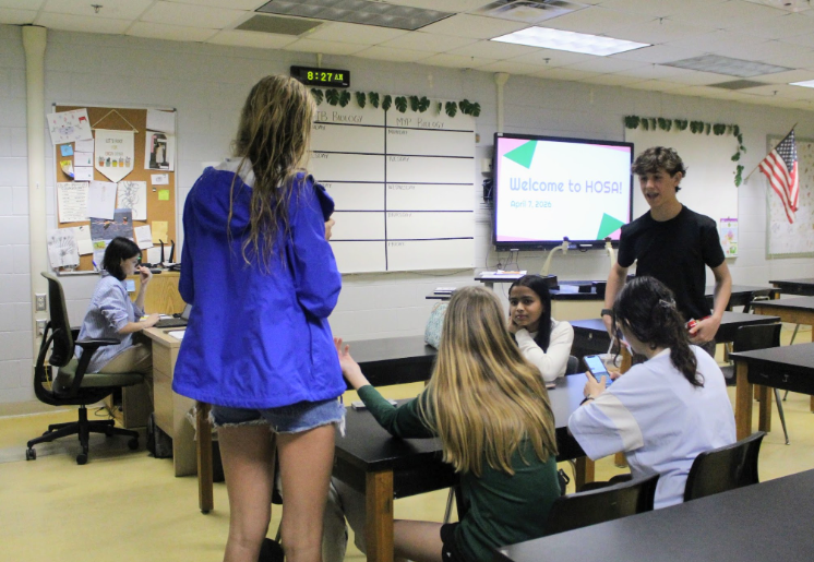 First Meeting: Freshman Rujula Mogre is sitting with her friends before the HOSA meeting begins in Ms.Todds classroom. The first meeting of the club was held on a Tuesday morning, with the club planning to have meetings on Tuesdays. Historian Addison Trent stated, “This year our first event is that we are making cards for teachers at our school just in time for teacher appreciation week.” The many events including competitions starting next year gave the club members things to look forward to. Photo by: Ayaana Gupta