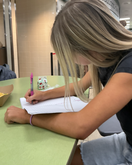 Planning Ahead: Olivia Eagle, a sophomore, completes her junior-year course selection sheet during lunch in the high school cafeteria. As students prepared for next year’s schedules this week, Eagle carefully reviewed her options before submitting her selections. “I wanted to challenge myself, but also make sure I could handle the workload,” she said. Eagle explained that she had started thinking about her schedule after counselors discussed graduation requirements and said she wanted to balance advanced classes with her personal interests. Photo By Chloe Strong