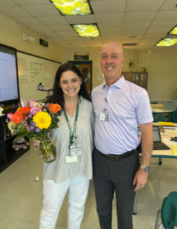 Chad Kirk and teacher of the year, M.s Hanus pose for a photo after Ms. Hanu learned about her award. “I learn more from them than they do from me.” Photo by Jen Williams.